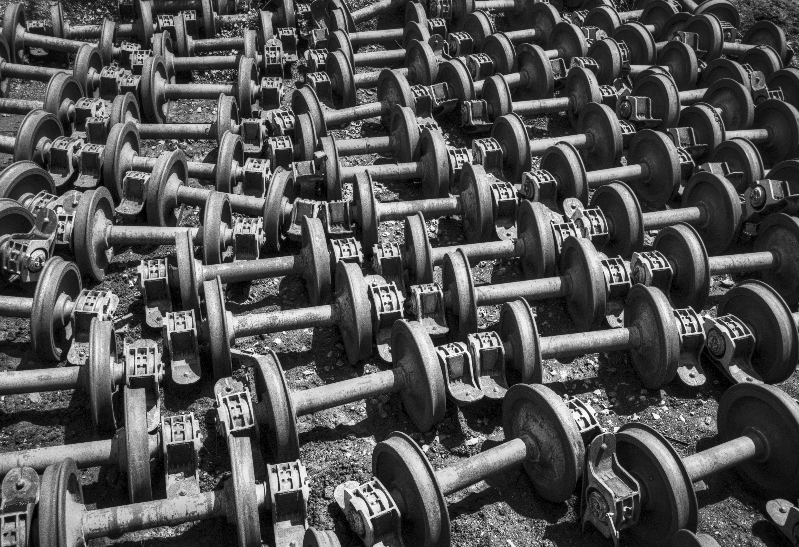 A large pattern of rusty train wheels arranged on the ground in an abandoned station.