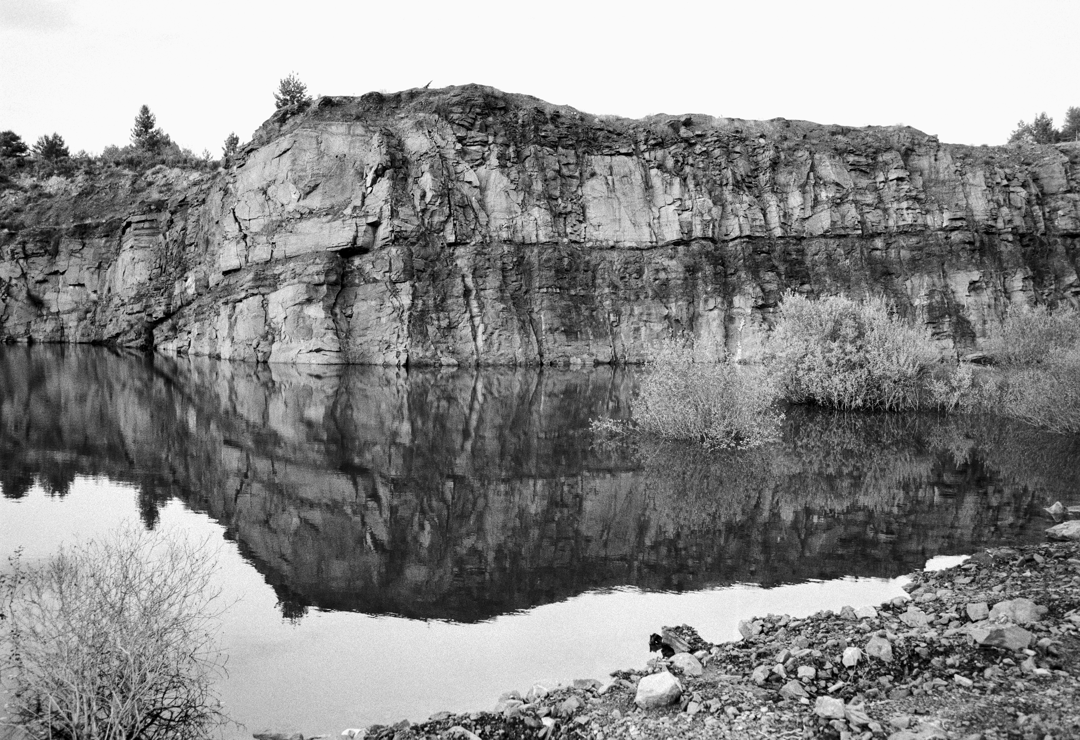 Rocky cliff reflected in the still waters of Laguna de los Gigantes, in Páramo del Sil.